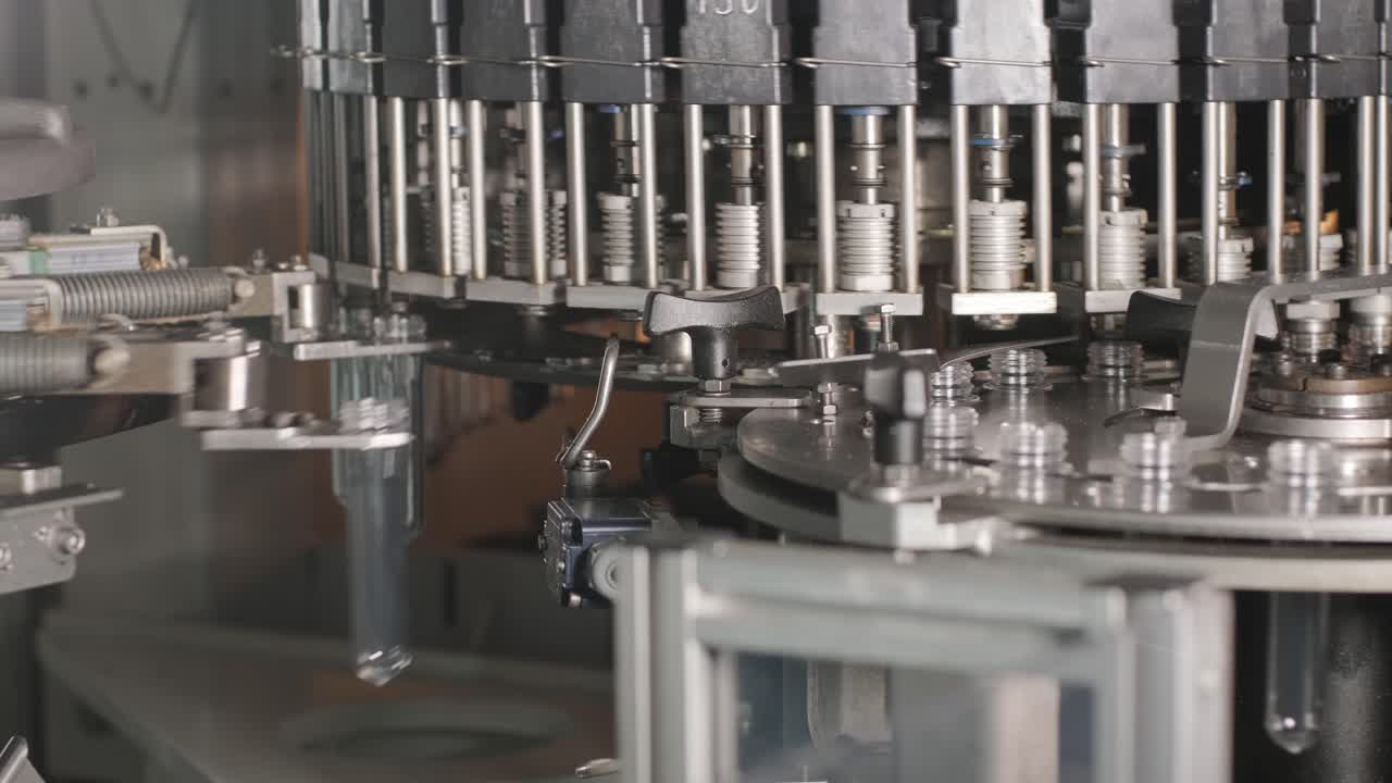 Automatic filling machine pours water into plastic PET bottles at modern beverage plant