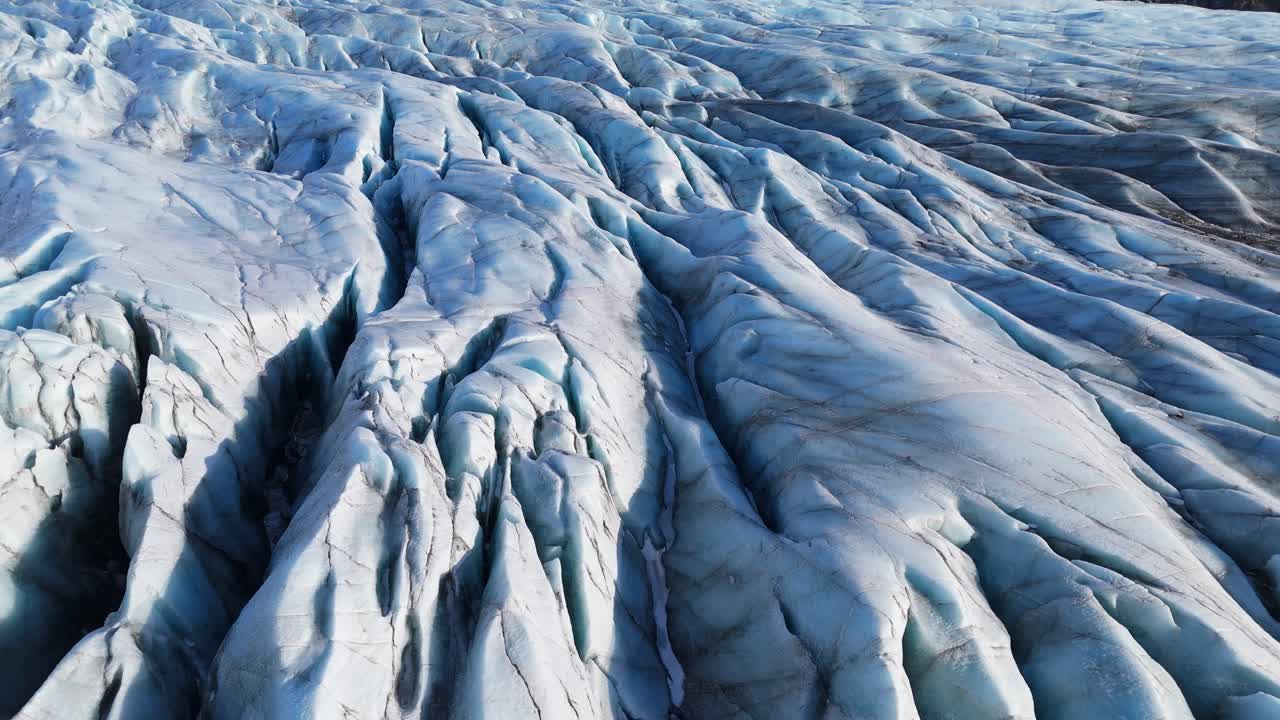 Aerial drone footage of a glacier in Iceland, with dramatic textures and landscapes resembling scenes from Interstellar highlighting the effects of global warming and climate change