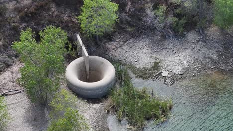 concrete drainage hole in bouquet reservoir santa clarita california aerial telephoto orbit 60fps