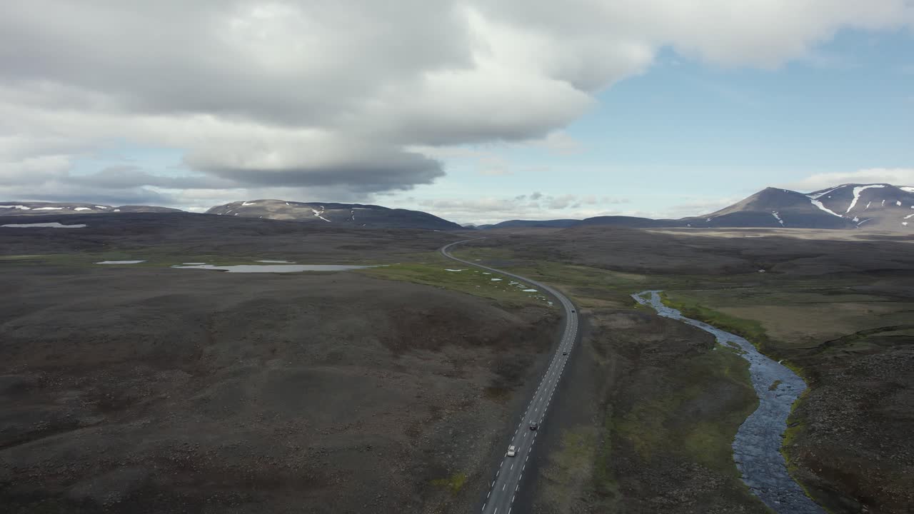 drone volando alto sobre un par de autos en una carretera en algún lugar del interior de islandia en 4k