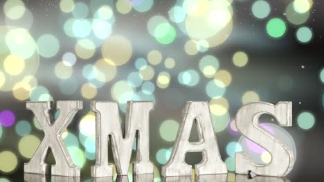 the letters xmas rotate on a glowing colored bokeh background.