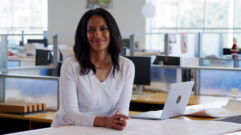 Middle-aged-businesswoman-smiles-in-an-open-plan-office