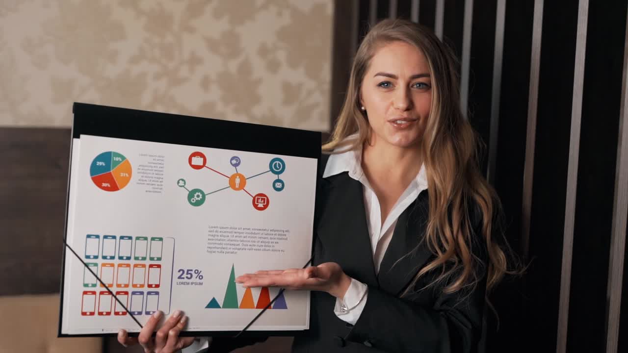 close-up portrait of a woman in a business suit showing a presentation on infographics looking at the camera