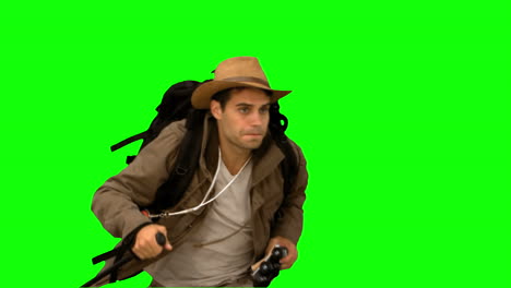 man orienteering while holding a hiking stick on green screen