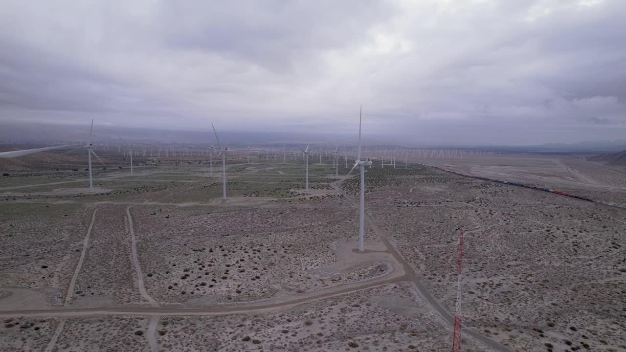 imágenes aéreas de un parque eólico en el desierto de palm springs en un día nublado, toma lenta