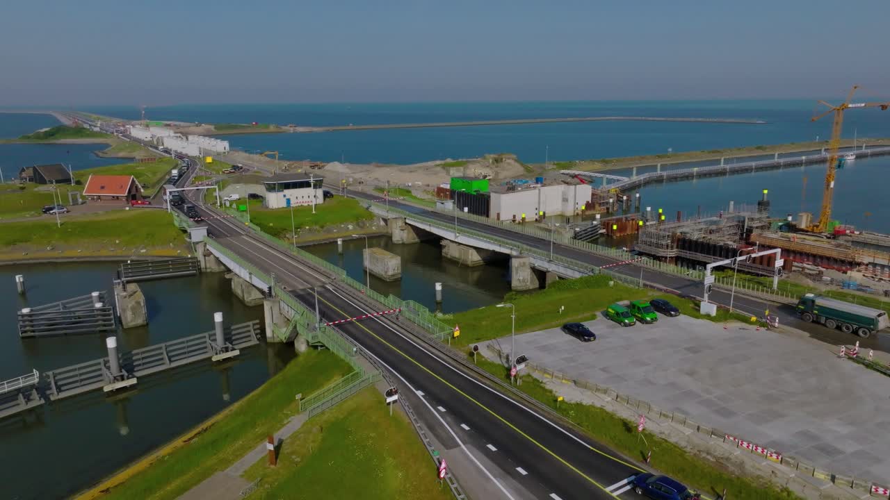 Drone semi orbit revealing the Afsluitdijk bridge and water locks connecting the IJsselmeer to the North Sea