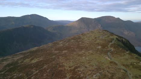 autumn mountain landscape at dawn with fast flight over to mountain summit of fleetwith pike, english lake district, cumbria, uk