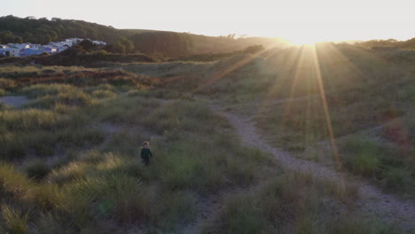 Toma-De-Drones-De-Niños-Jugando-En-Dunas-De-Arena-En-Una-Playa-De-Invierno-Mientras-Se-Pone-El-Sol.