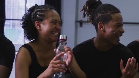 multi-ethnic group of fit male and female modern dancers taking a break