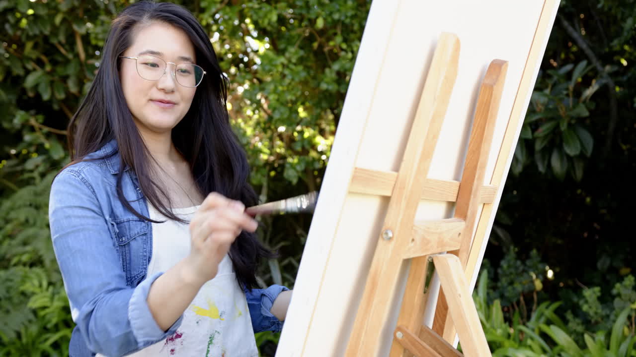 Painting on canvas, woman with glasses enjoying outdoor art session