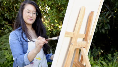 painting on canvas, woman with glasses enjoying outdoor art session