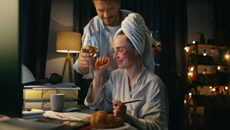 family enjoying together home closeup. man bringing woman wine glass at evening