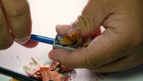 Imágenes-De-Manos-Afilando-Lentamente-Un-Lápiz-Y-Algunos-Lápices-De-Colores-Con-Un-Sacapuntas-De-Cuña