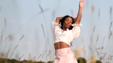 black woman being playful in field posing to camera in a warm sunny day during sunset