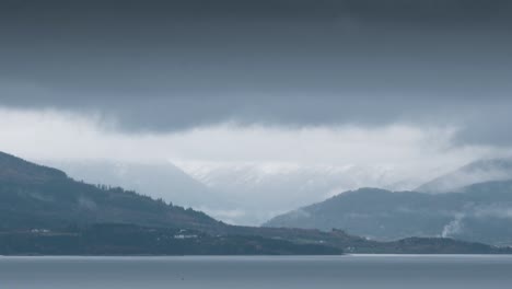 Dark sky hanging above small mountains and seascape