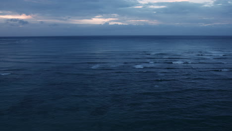 deep blue waves rolling in at waikiki bay with brilliant morning cloudscape, hawaii, tilt up