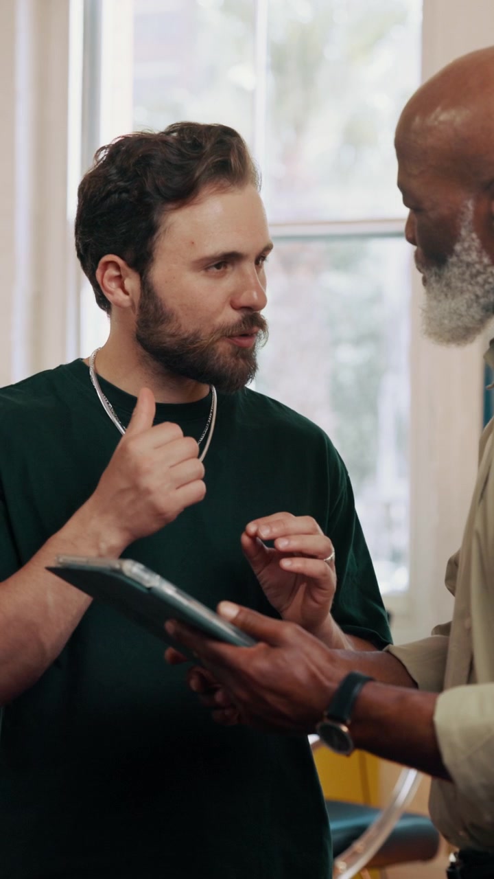 Two Men Discussing Business Strategy Using a Digital Tablet