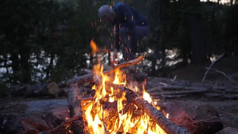 Lagerfeuer-Mit-Mann,-Der-Feuerholz-Hackt,-Zeitlupenaufnahme