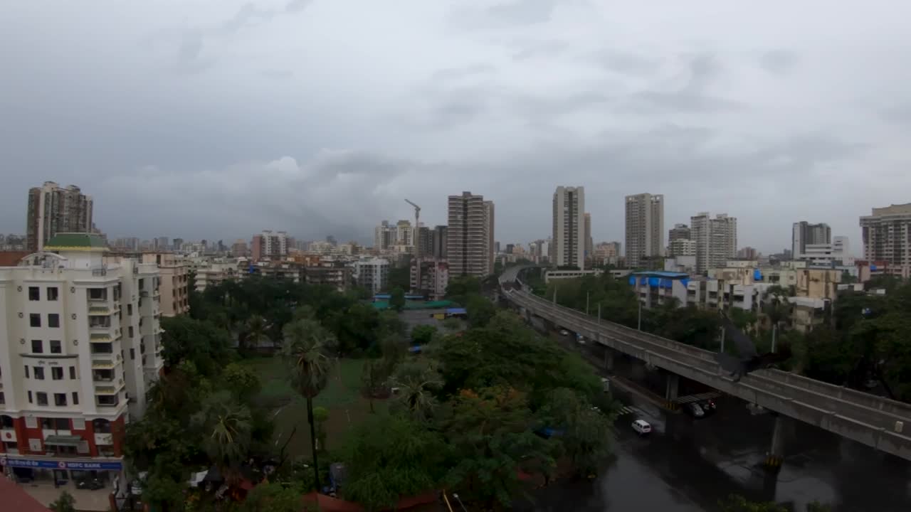 el cuervo encapuchado vuela desde un edificio que pasa por un ferrocarril con el paisaje urbano en el fondo en mumbai, india