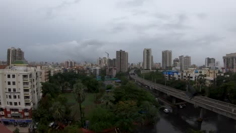 El-Cuervo-Encapuchado-Vuela-Desde-Un-Edificio-Que-Pasa-Un-Ferrocarril-Con-Paisaje-Urbano-Al-Fondo-En-Mumbai,-India