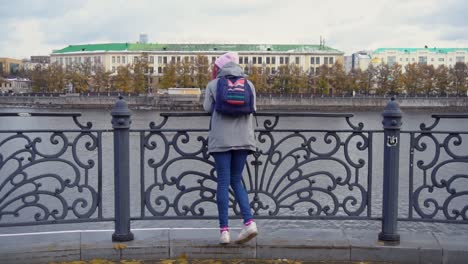 woman by the river in a cityscape