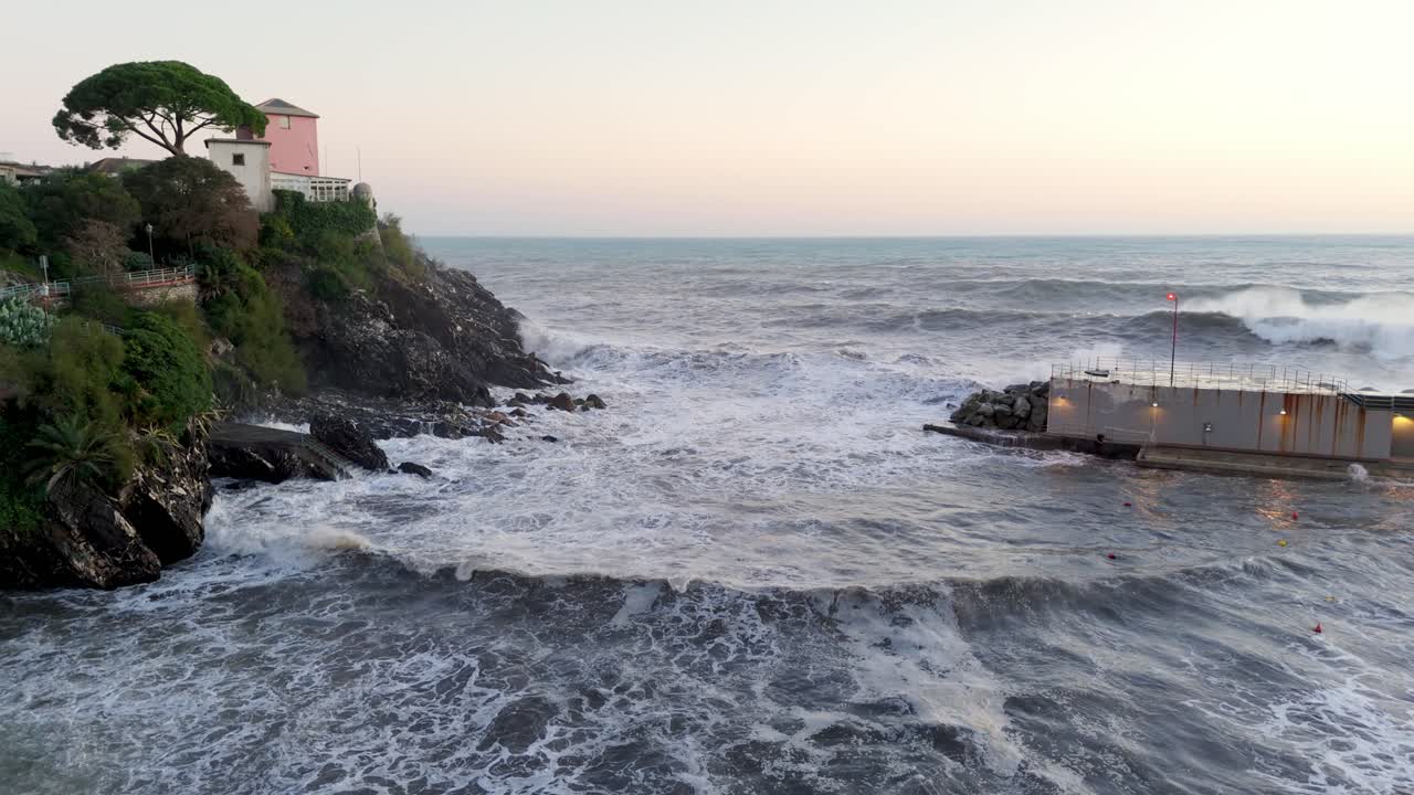 Big sea waves flowing into harbor through narrow pass dammed by pier