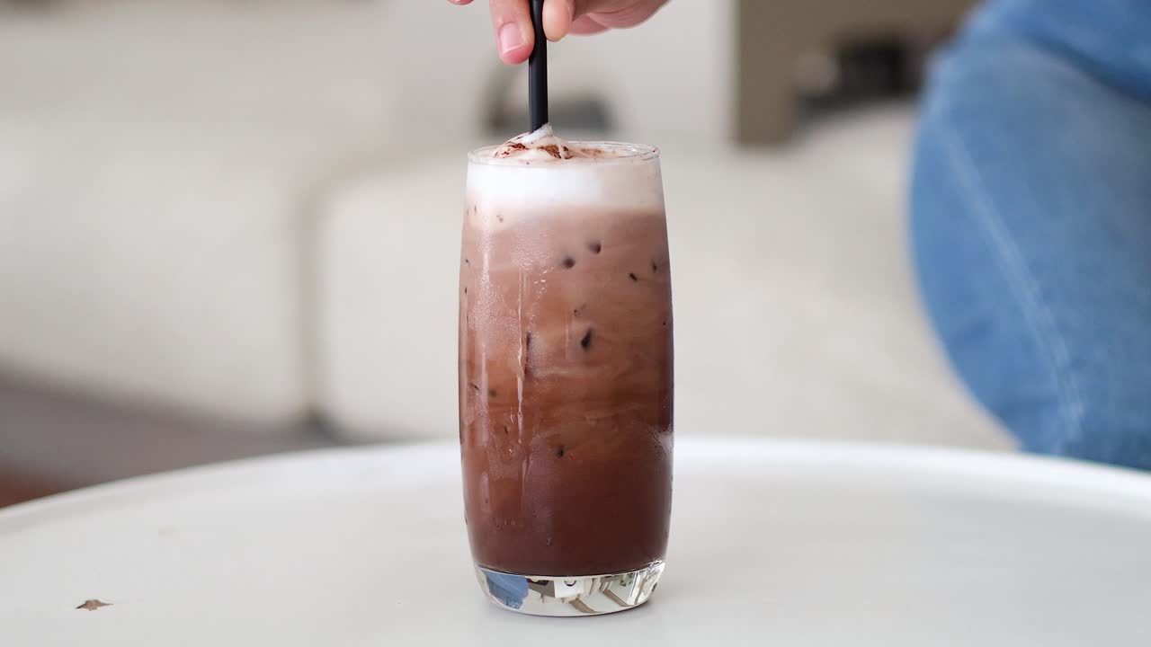 Versamento di latte nel caffè freddo nel tempo