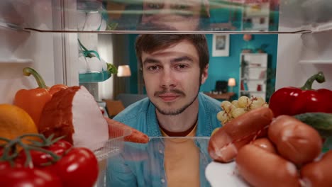 hombre mirando dentro de un refrigerador