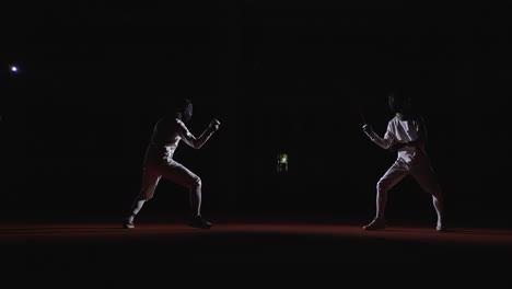 two fencers compete in a fencing match