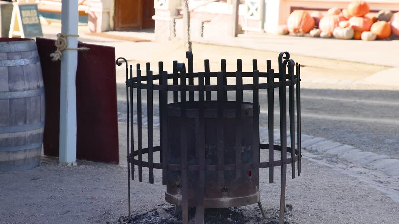 An iron fire pit stands in a sunlit, historic street setting in Ballarat, Victoria, Australia. The scene captures a rustic atmosphere