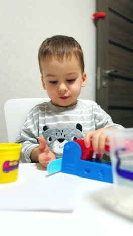 little baby boy playing with colorful toys. playful cute kid with plastic toy. vertical video.