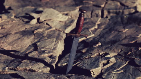 excalibur sword in rocky stone at sunset