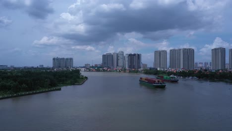 Toma-Aérea-De-Grandes-Barcos-Fluviales-Que-Transportan-Contenedores-De-Envío-En-El-Río-Saigón-En-La-Ciudad-De-Ho-Chi-Minh