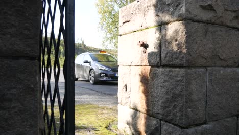 a car driving through the entrance of a cemetery in sweden