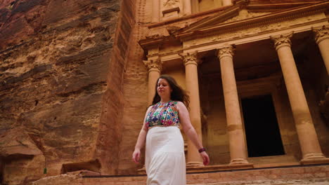 female traveler walking down the stairs outside the treasury in archaeological city of petra in jordan