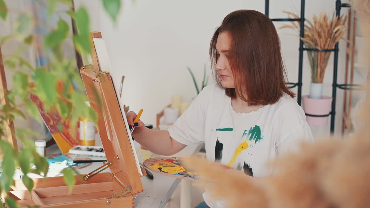 액자를 그리는 빨간 머리의 젊은 여성 화가 1