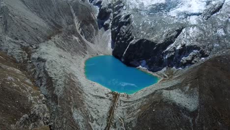 pristine turquoise waters of laguna 69 in huaraz, peru, surrounded by snow capped peaks