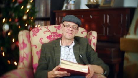 a senior man closes a book after reading a christmas story