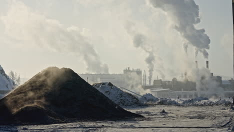 industrial site in winter with smoke and snow