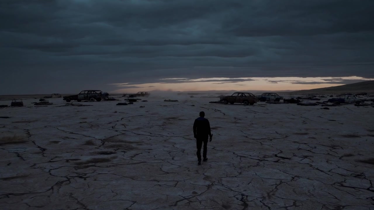 Man Walking Through Abandoned Car Graveyard in Desert