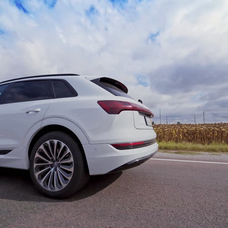 white luxury car on road on the field background. very fast driving of audi car on highway under beautiful sky at daylight.