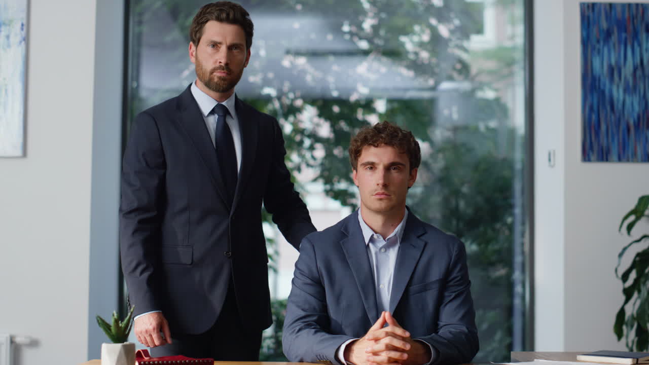 Two businesspeople looking camera at panoramic cabinet closeup. Partners posing