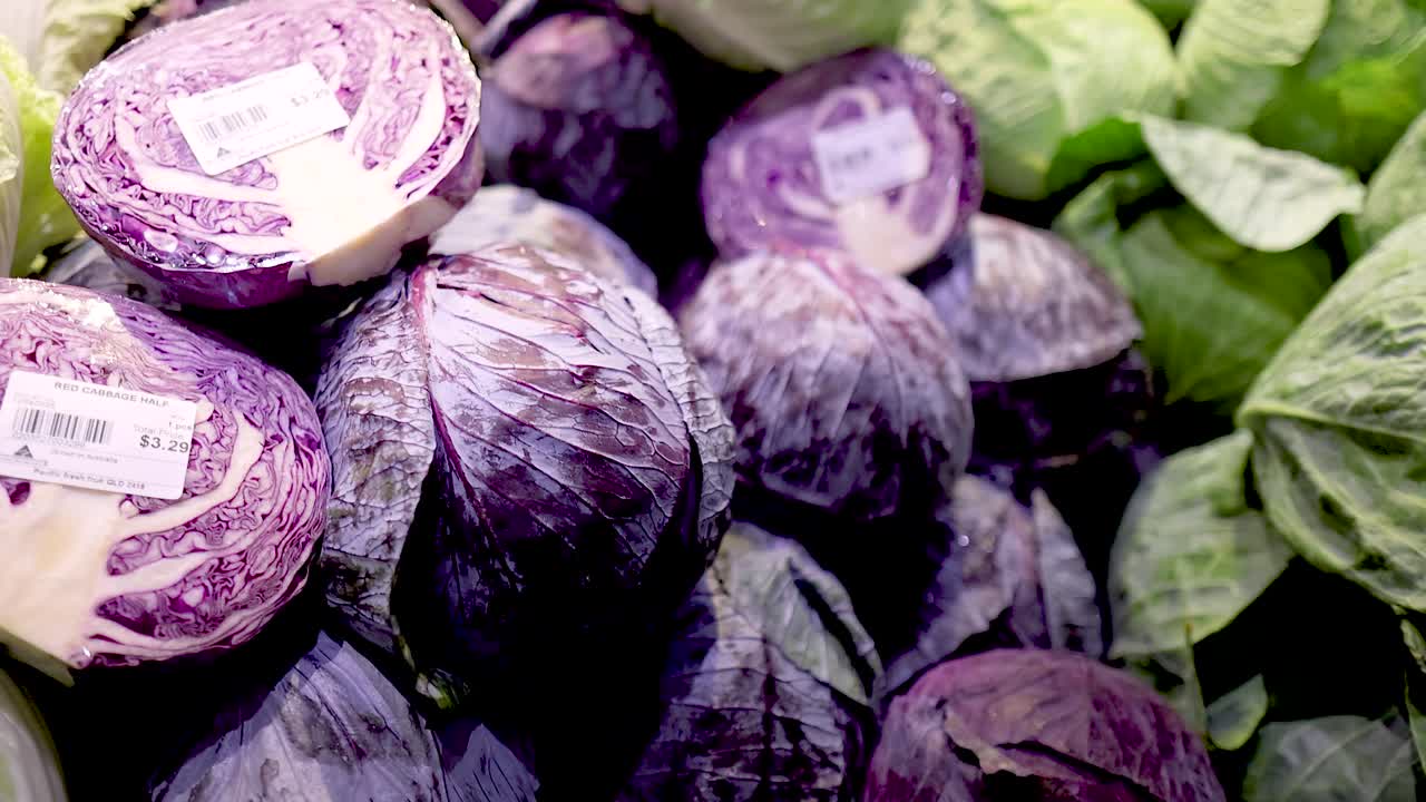 A colorful arrangement of red cabbages in a well-lit Gold Coast supermarket, highlighting fresh produce with clear pricing