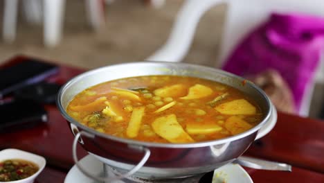 simmering yellow curry with fish and vegetables