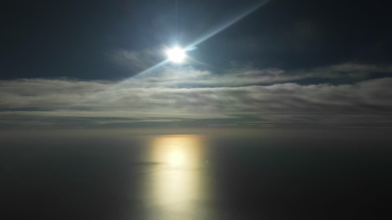 극적인 겨울 하늘은 색과 노란색의 태양으로 은 구름으로 가려져 있습니다.