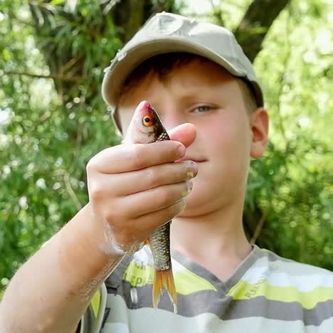 boy holding a small fish