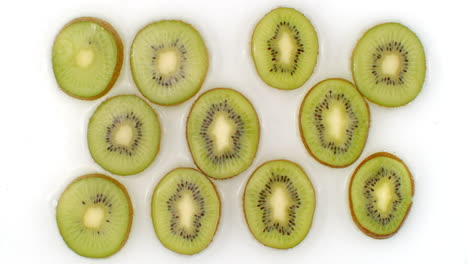 Sobre-Un-Fondo-Blanco,-Los-Kiwis-En-Rodajas-Se-Rocían-Con-Agua.-Gotas-De-Agua-Jugoso-Kiwi.