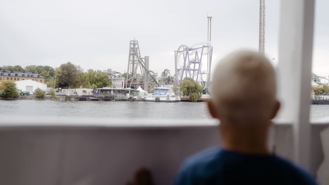 niño pequeño mirando cerrado parque de atracciones espeluznante equitación barco de pasajeros barco ferry crucero interesante de cerca inspeccionando montañas rusas tiovivo alegre memoria pasar tiempo familia felicidad diversión