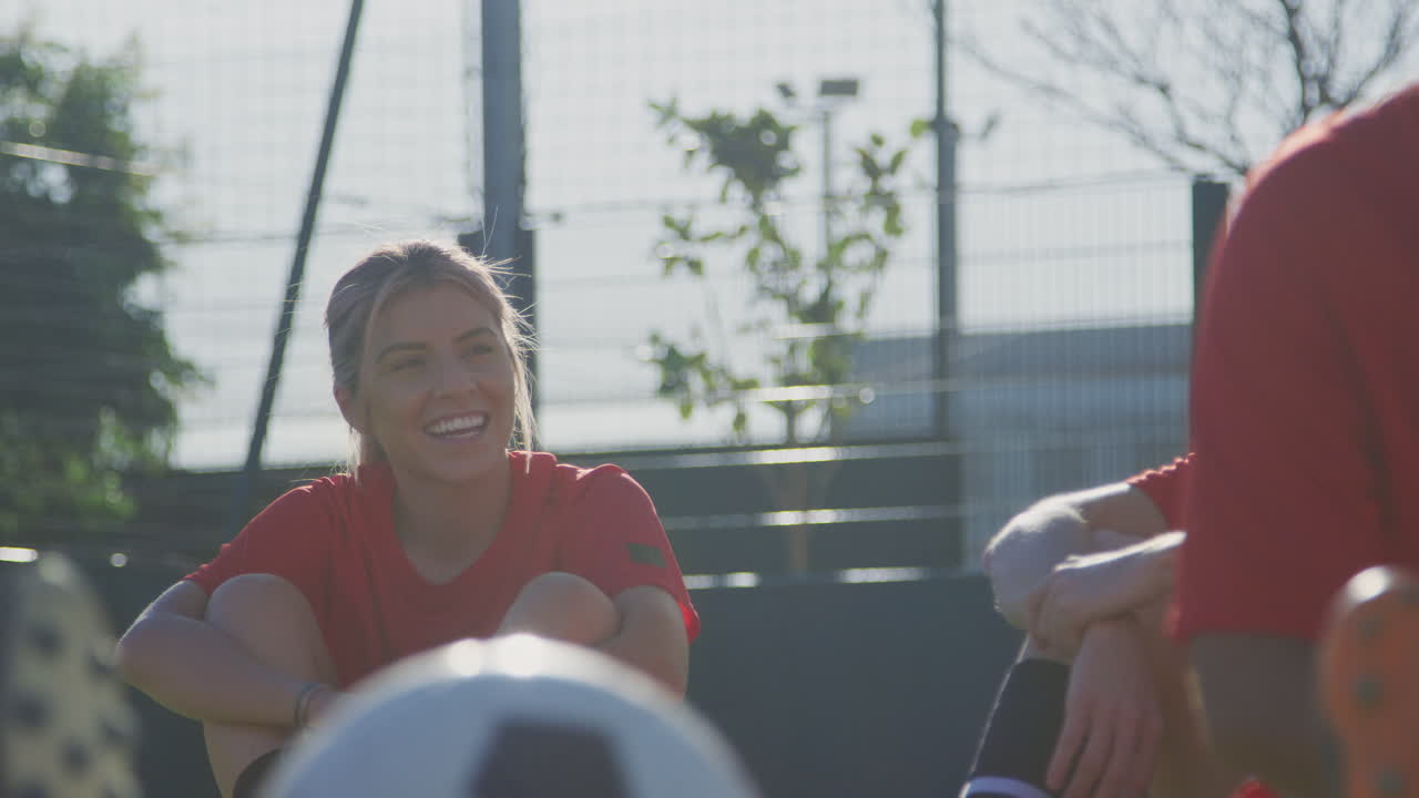 여자 축구 팀 이 경기 전 열기 훈련 중 휴식 기간 에 대화 하고 있다