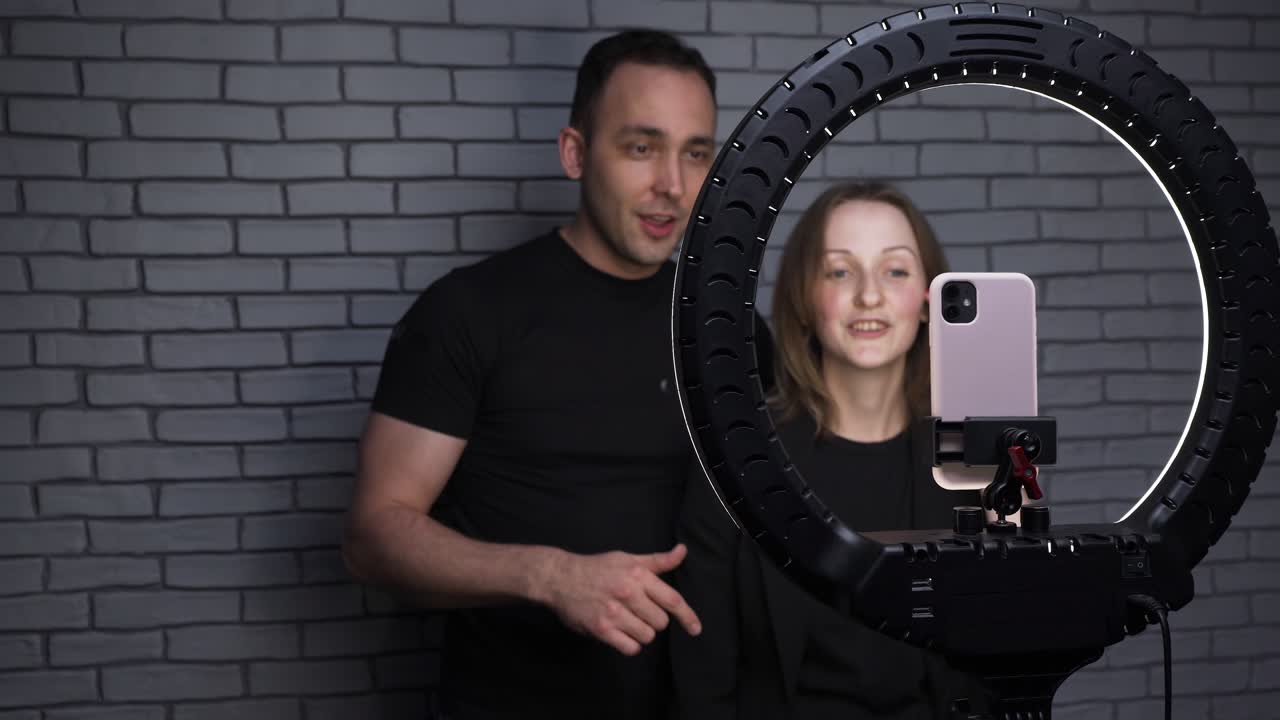 imágenes de una pareja con un teléfono inteligente en el fondo de una pared de ladrillo